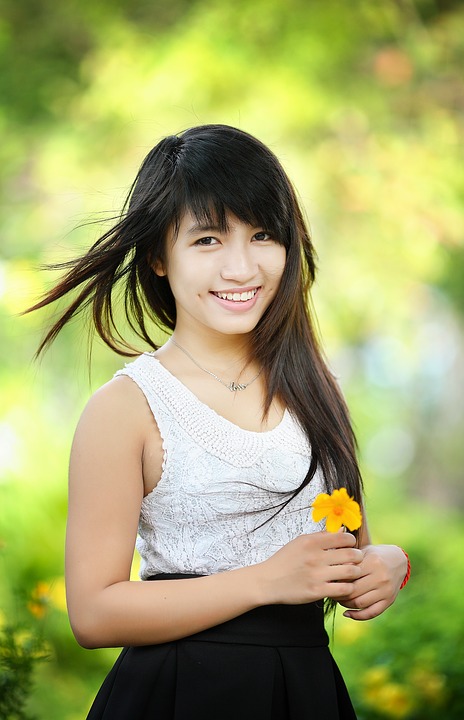 Woman holding a flower and smiling
