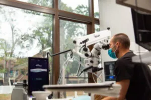 Endodontist using a surgical microscope during a root canal at Elite Endodontics in Pensacola